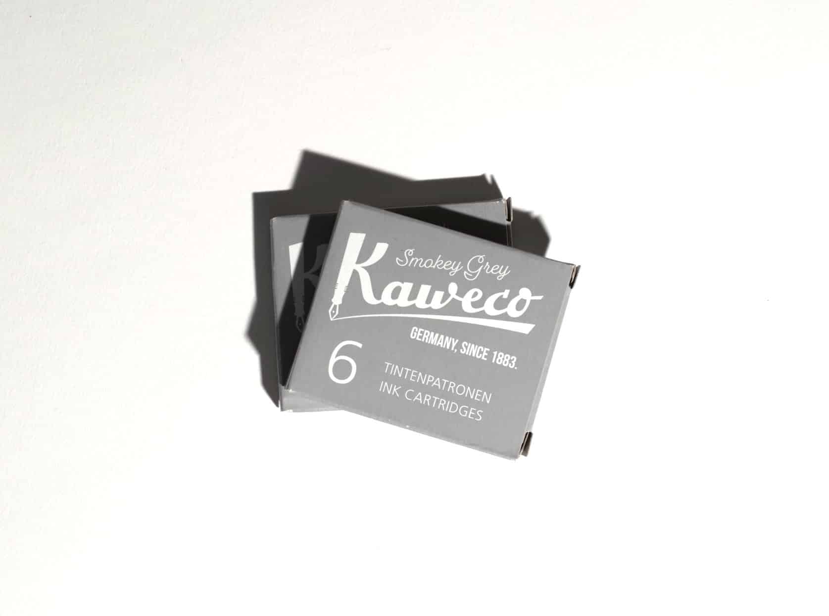 Two boxes of ink cartridges lie on a white surface. Text on packaging reads: Kaweco. Smokey Grey. Germany, since 1883. 6 Tintenpatronen. Ink Cartridges.