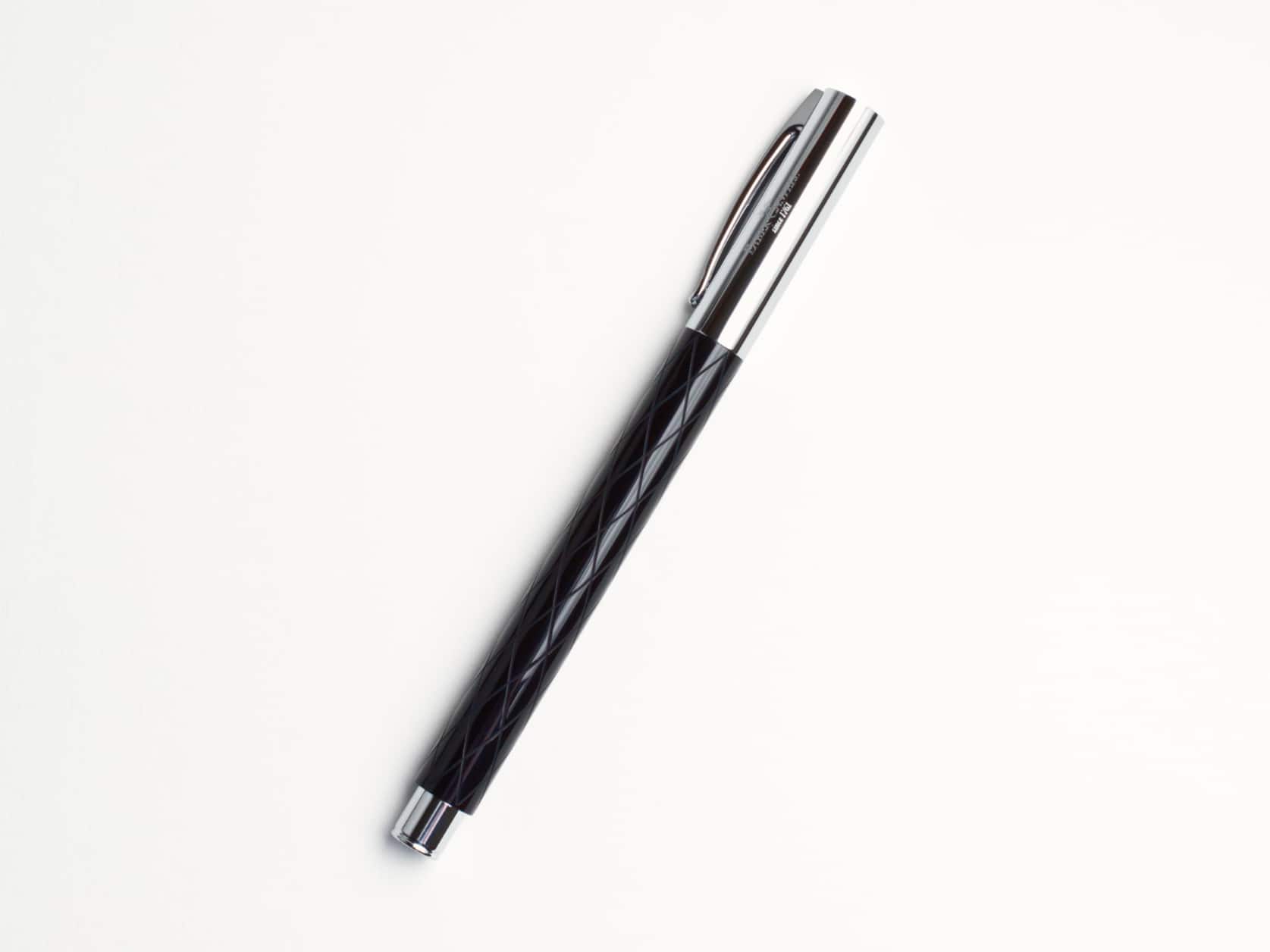 Black fountain pen with a shiny diamond-patterned body and a shiny metal cap and end. Cap has Faber-Castell logo