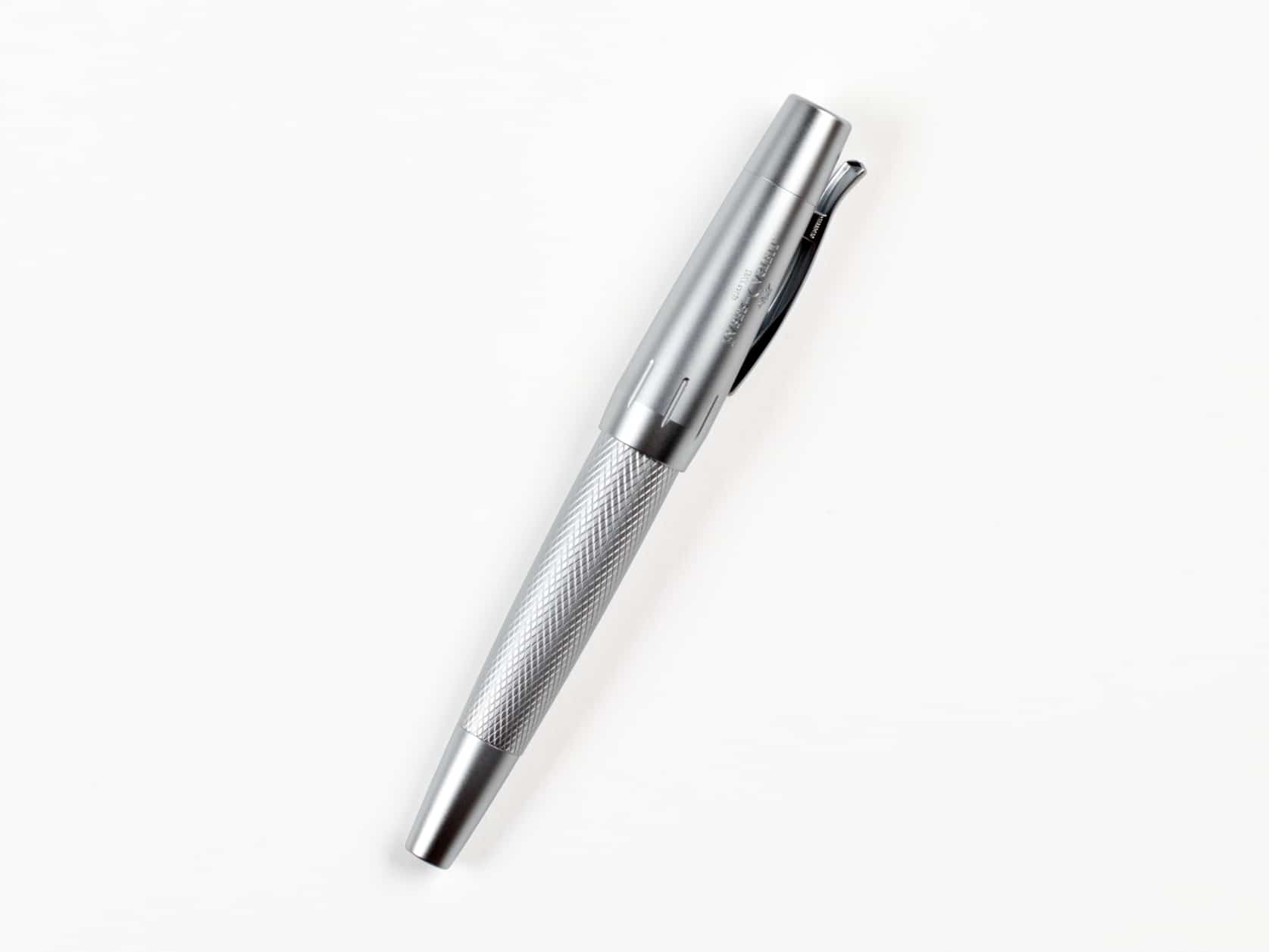 Thick silver pen with a clip and a textured body. Cap has Faber-Castell logo on it.