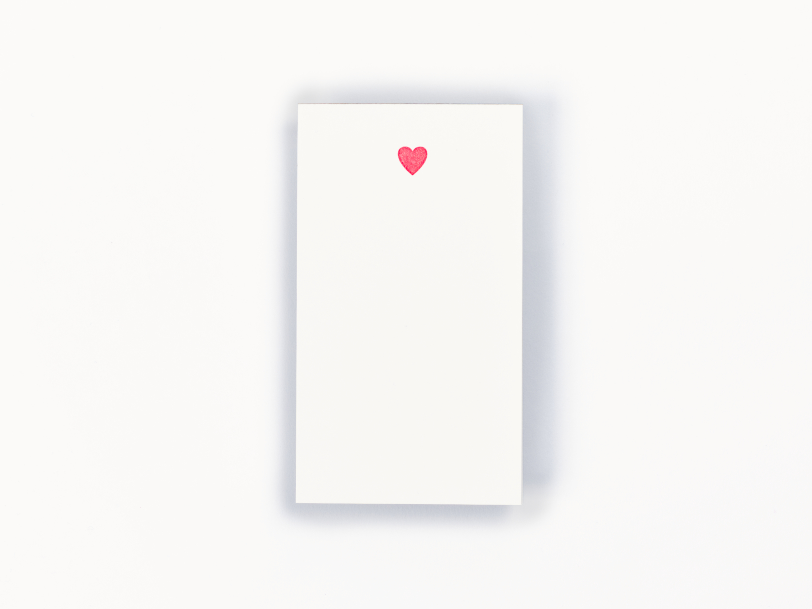 White noteapad with a red heart at the top