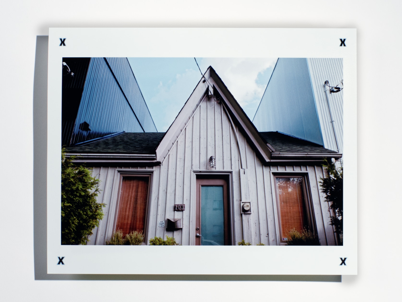 Photography print of a white house between two large buildings