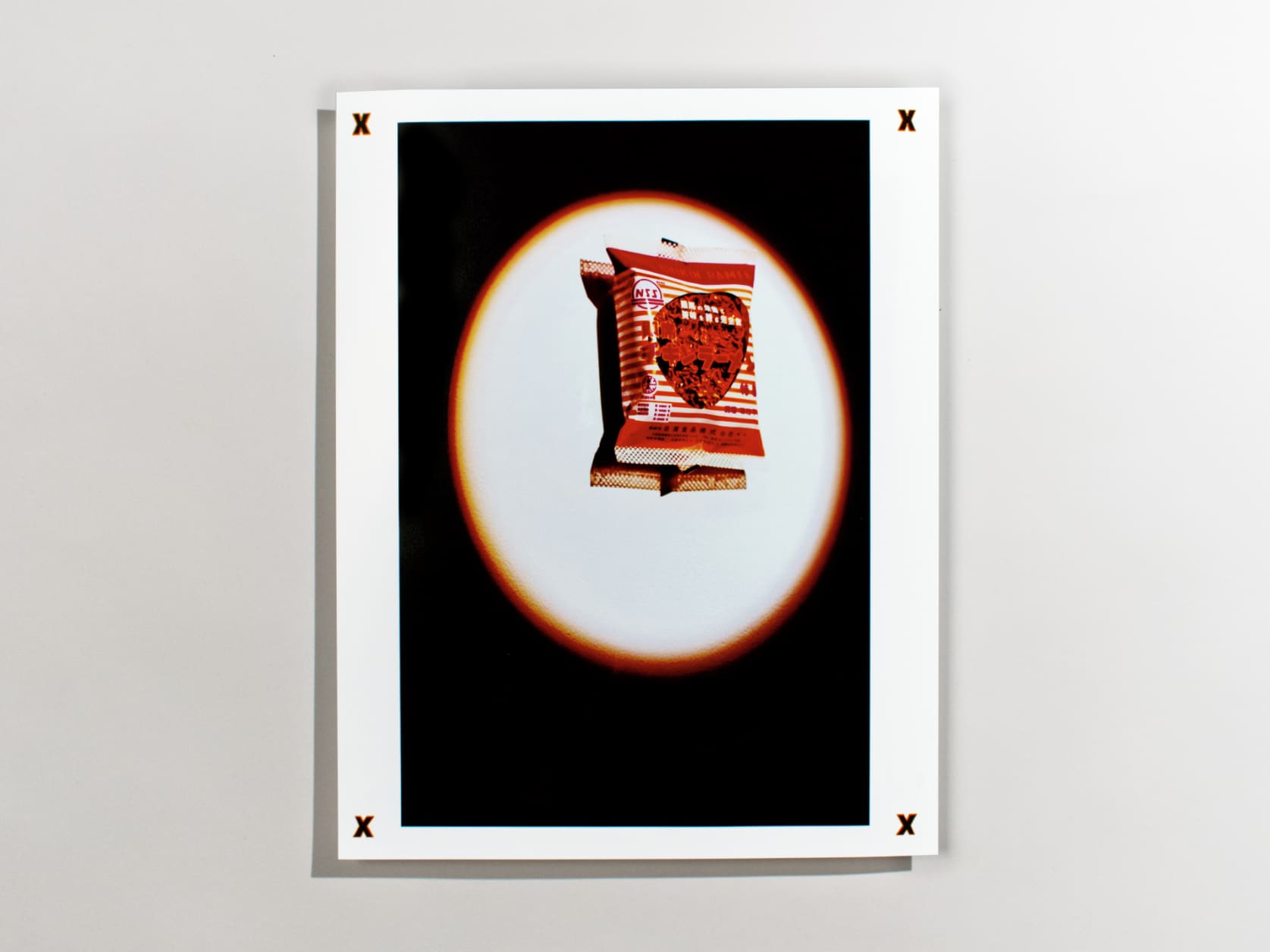 Photography print of a pack of ramen affixed on a wall under a spotlight